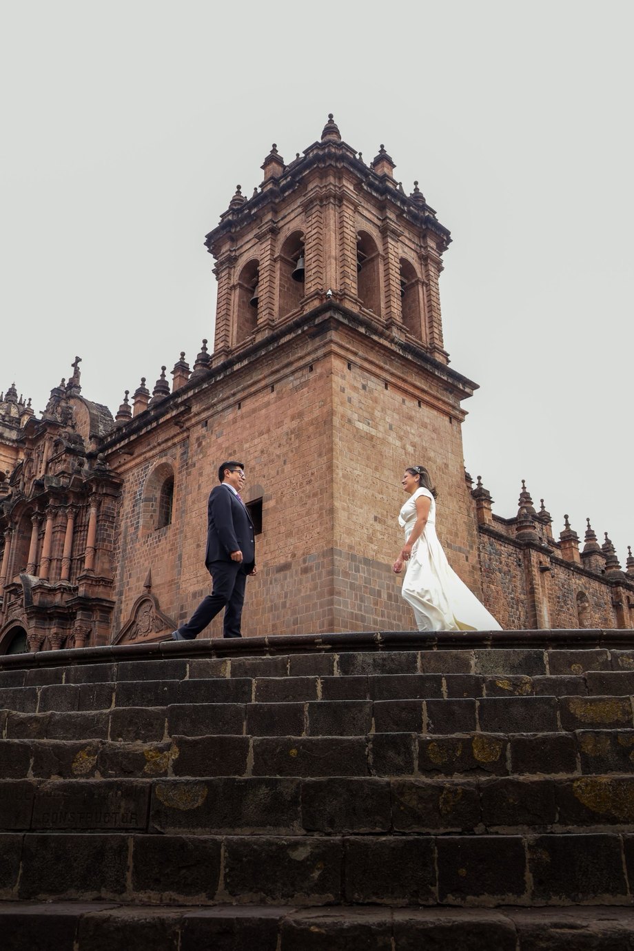 A bride and groom on the cathedral steps in Cusco, Peru